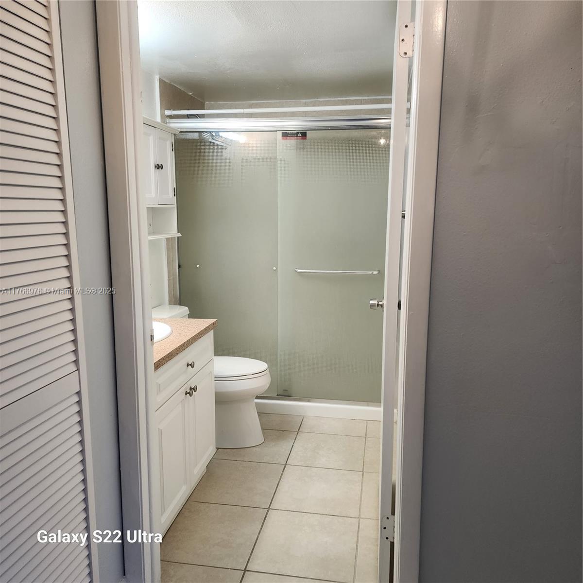 8200 Southwest 210th Street, Unit 111 Cutler Bay, FL 33189 - Photo 5 of 23 a bathroom with a granite countertop shower and a toilet