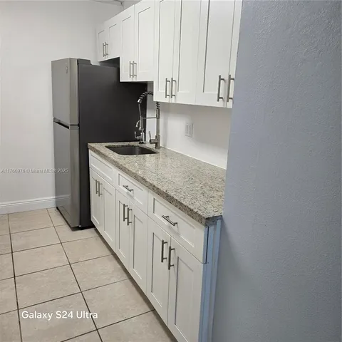 a kitchen with stainless steel appliances granite countertop a refrigerator and a stove