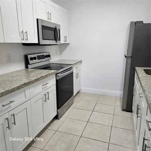 a kitchen with cabinets stainless steel appliances and a sink
