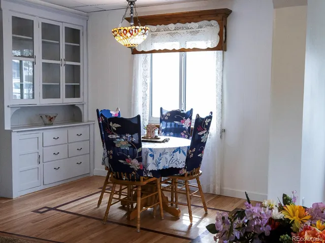 a kitchen with granite countertop a refrigerator cabinets and wooden floor