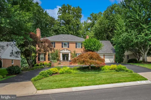 a front view of a house with a yard and trees