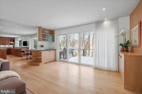 a kitchen with stainless steel appliances granite countertop a stove top oven a sink dishwasher a dining table and chairs with wooden floor