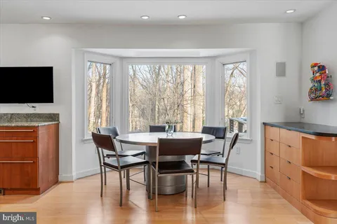 a view of a a dining room with furniture window and wooden floor