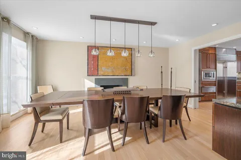 a large white kitchen with kitchen island a large counter top space a sink stainless steel appliances and cabinets
