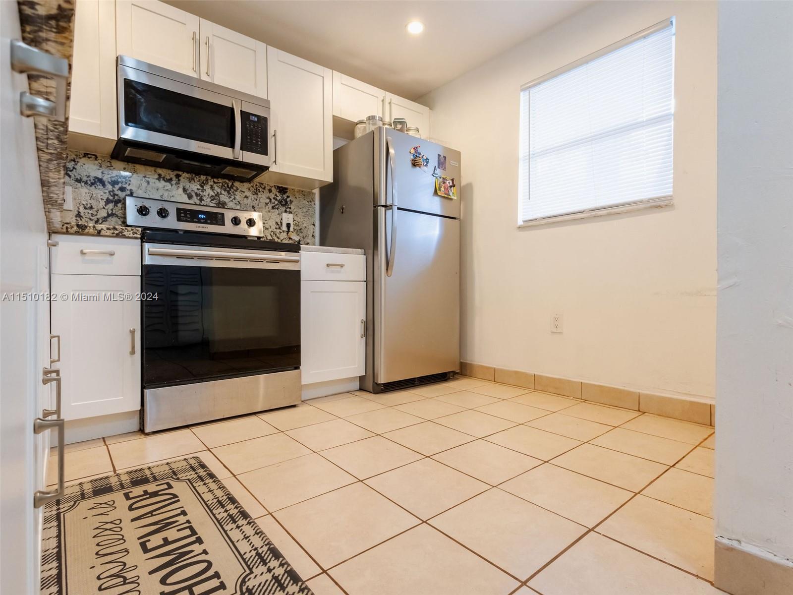 8331 Sands Point Boulevard, Unit C108 Tamarac, FL 33321 - Photo 12 of 46 a kitchen with stainless steel appliances a stove a microwave and a refrigerator
