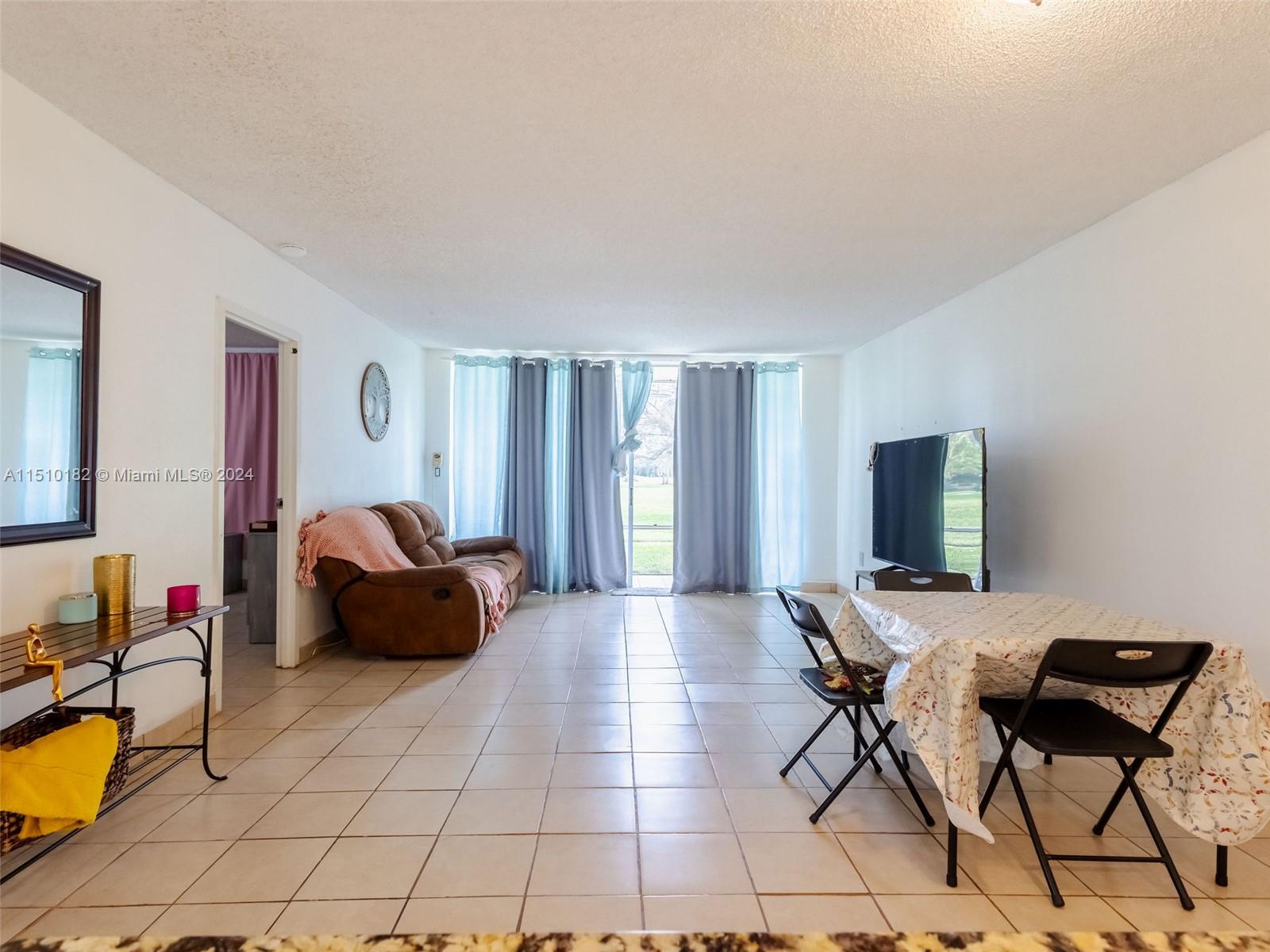 8331 Sands Point Boulevard, Unit C108 Tamarac, FL 33321 - Photo 19 of 46 a living room with furniture and a flat screen tv