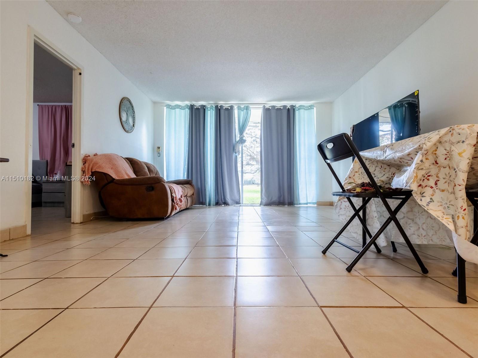 8331 Sands Point Boulevard, Unit C108 Tamarac, FL 33321 - Photo 21 of 46 a living room with furniture and a table
