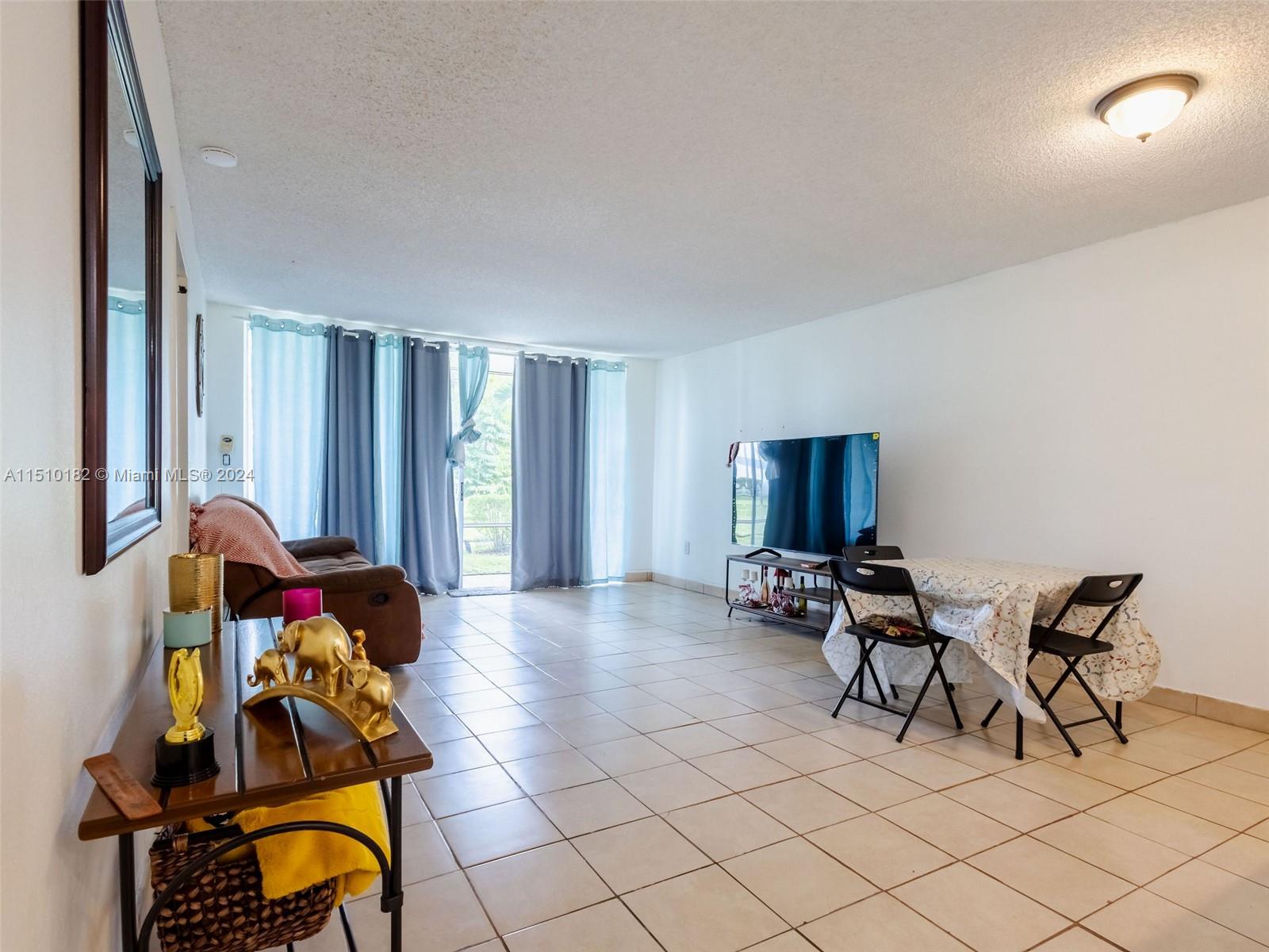 8331 Sands Point Boulevard, Unit C108 Tamarac, FL 33321 - Photo 23 of 46 a living room with furniture and window