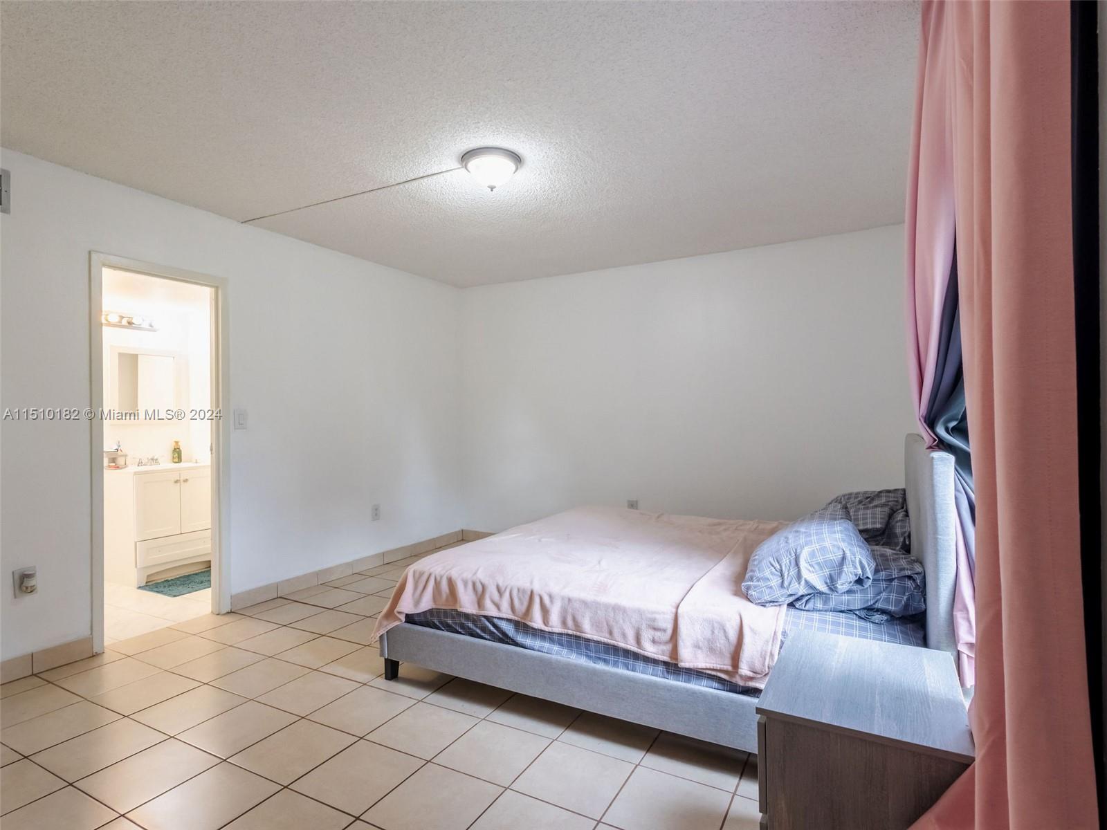 8331 Sands Point Boulevard, Unit C108 Tamarac, FL 33321 - Photo 26 of 46 a bedroom with a bed and a window