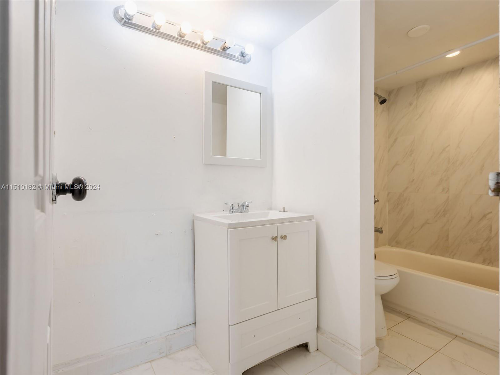 8331 Sands Point Boulevard, Unit C108 Tamarac, FL 33321 - Photo 27 of 46 a bathroom with a sink a toilet and shower