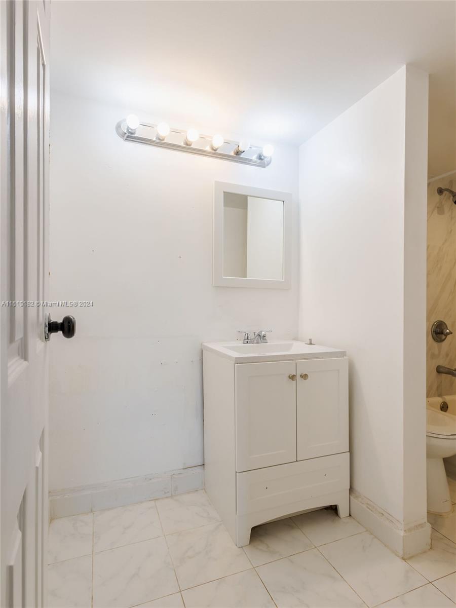 8331 Sands Point Boulevard, Unit C108 Tamarac, FL 33321 - Photo 28 of 46 a bathroom with a sink vanity and mirror