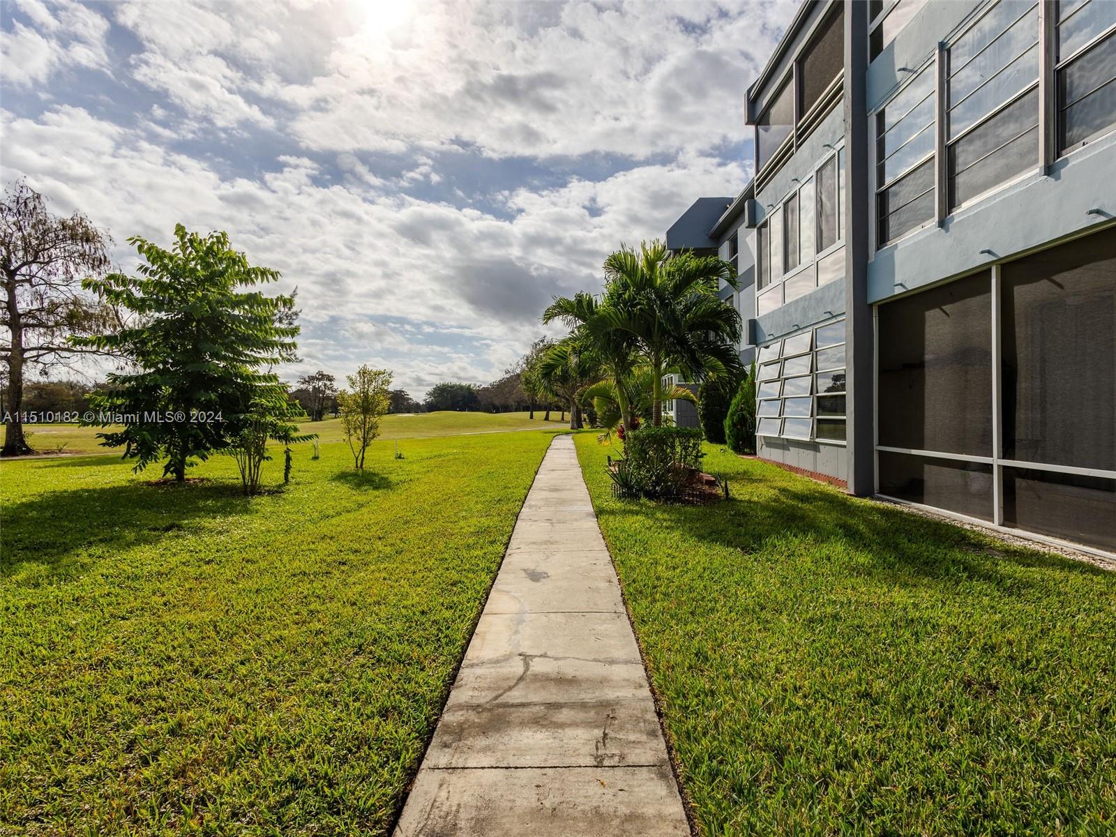 8331 Sands Point Boulevard, Unit C108 Tamarac, FL 33321 - Photo 3 of 46 a view of a pathway with a yard
