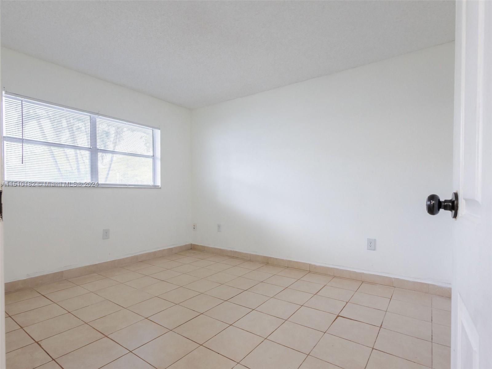 8331 Sands Point Boulevard, Unit C108 Tamarac, FL 33321 - Photo 31 of 46 an empty room with windows