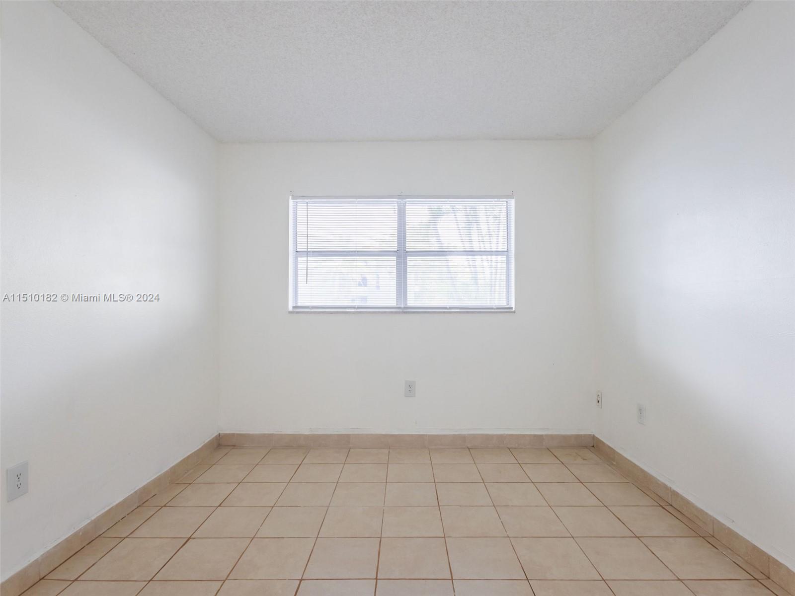 8331 Sands Point Boulevard, Unit C108 Tamarac, FL 33321 - Photo 32 of 46 an empty room with a window