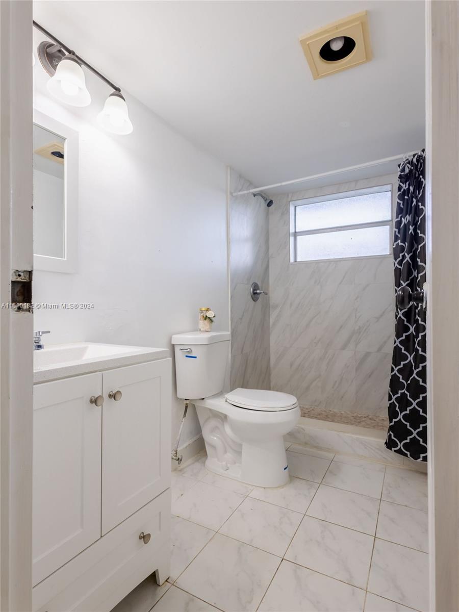 8331 Sands Point Boulevard, Unit C108 Tamarac, FL 33321 - Photo 36 of 46 a bathroom with a toilet sink and shower