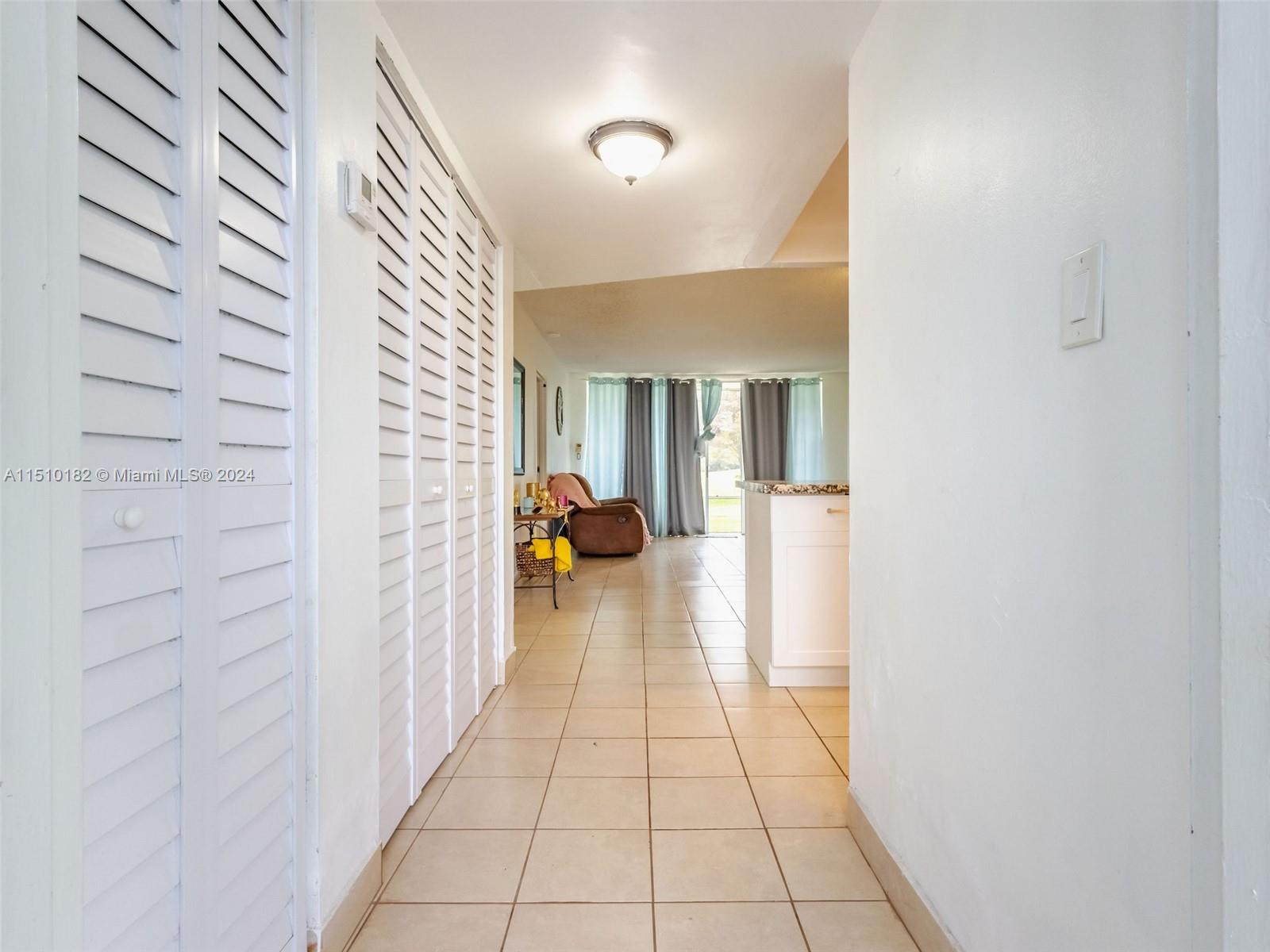 8331 Sands Point Boulevard, Unit C108 Tamarac, FL 33321 - Photo 37 of 46 a hallway with a closet and a bathroom