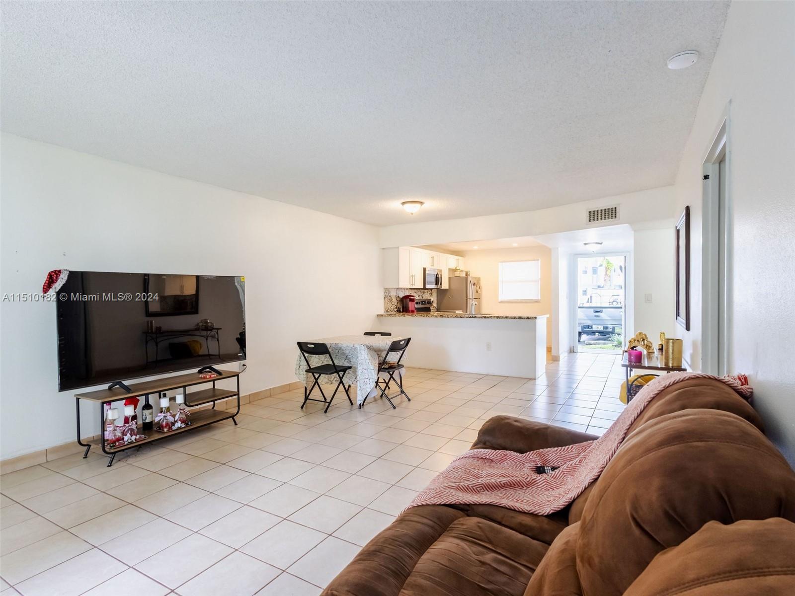 8331 Sands Point Boulevard, Unit C108 Tamarac, FL 33321 - Photo 9 of 46 a living room with furniture and a flat screen tv