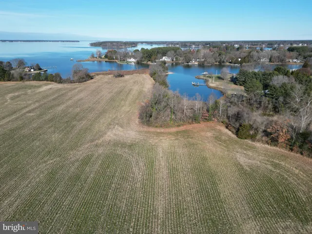 an aerial view of ocean with residential house and outdoor space