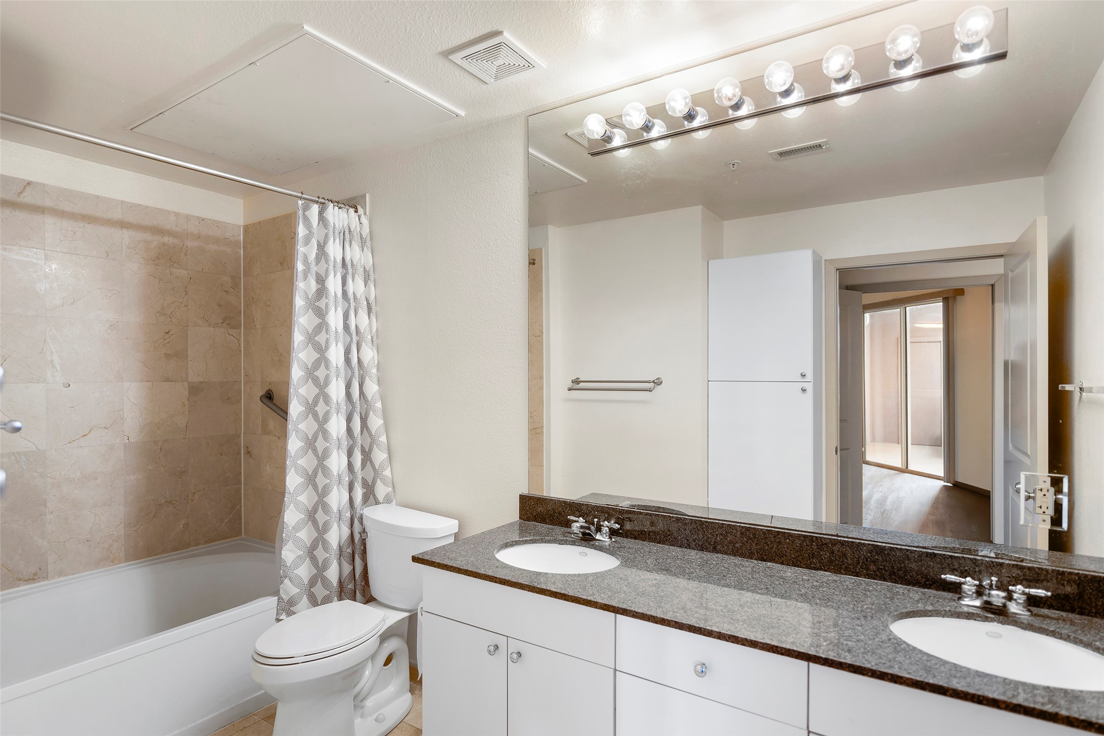 3505 Sage Road, Unit 314 Houston, TX 77056 - Photo 12 of 24 a bathroom with a granite countertop sink a toilet a mirror a bathtub and shower