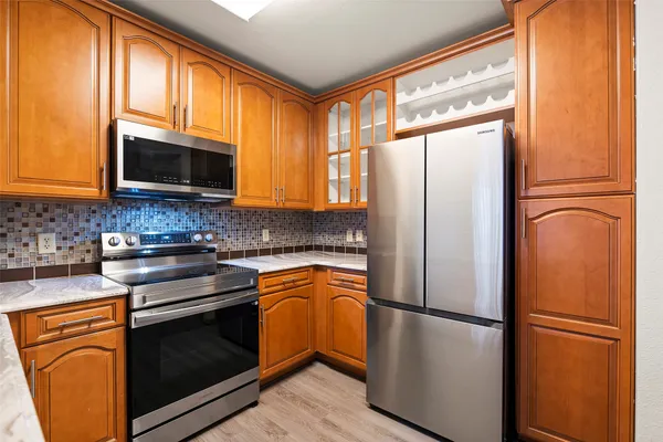 a kitchen with stainless steel appliances granite countertop a refrigerator a microwave a sink and cabinets