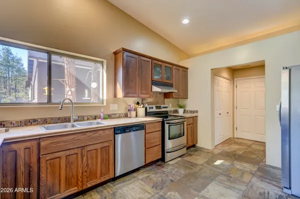 a kitchen with stainless steel appliances granite countertop a refrigerator and a stove