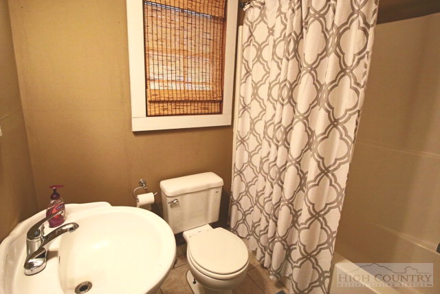 148 Grady Winkler Road Boone, NC 28607 - Photo 11 of 24 a white toilet sitting next to a bathroom sink and vanity