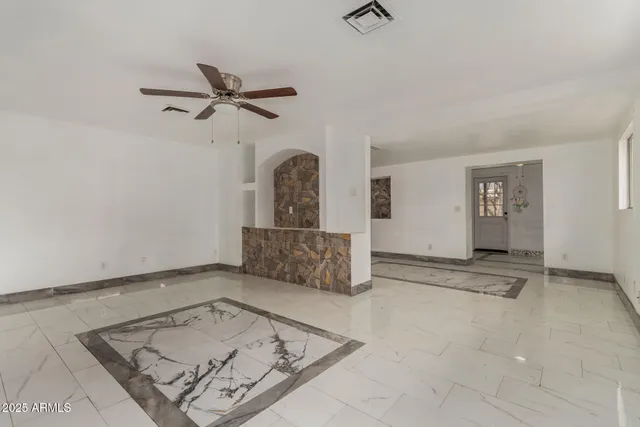 a view of kitchen with refrigerator and white cabinets