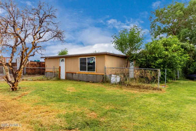 a view of a house with backyard and sitting area