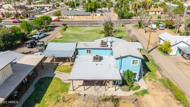 an aerial view of a residential houses with outdoor space and parking