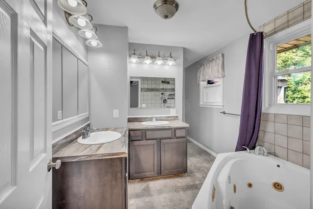 a bathroom with a tub sink and mirror