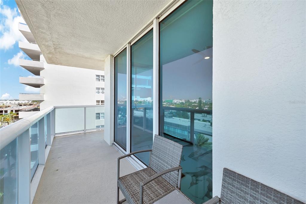 9201 Collins Avenue, Unit 821 Surfside, FL 33154 - Photo 16 of 60 a open kitchen with white cabinets and a glass door