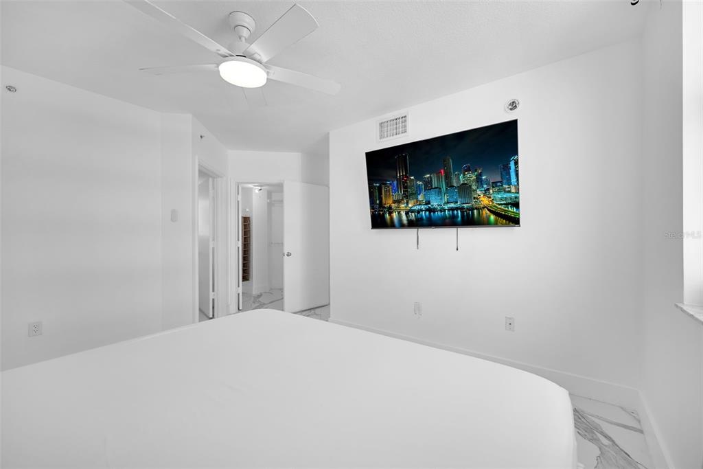 9201 Collins Avenue, Unit 821 Surfside, FL 33154 - Photo 35 of 60 a bedroom with a bed and a flat screen tv