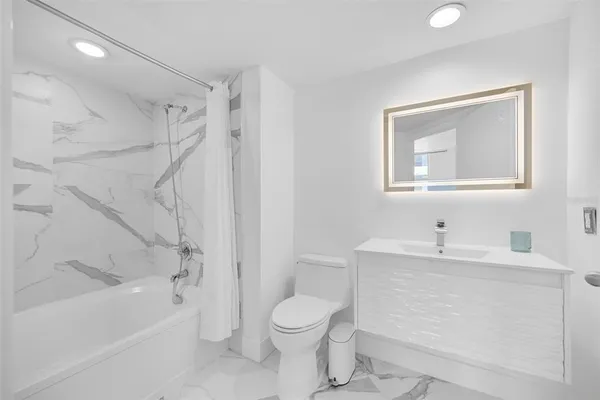 a en suite bathroom with a granite countertop sink and a mirror