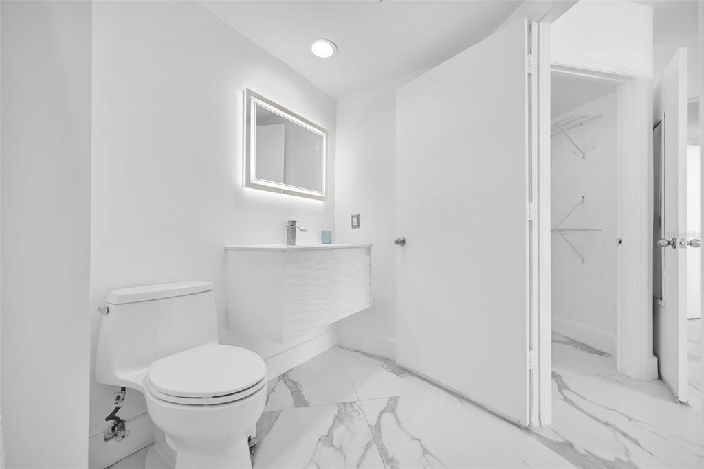 9201 Collins Avenue, Unit 821 Surfside, FL 33154 - Photo 39 of 60 a white toilet sitting next to a bathroom sink