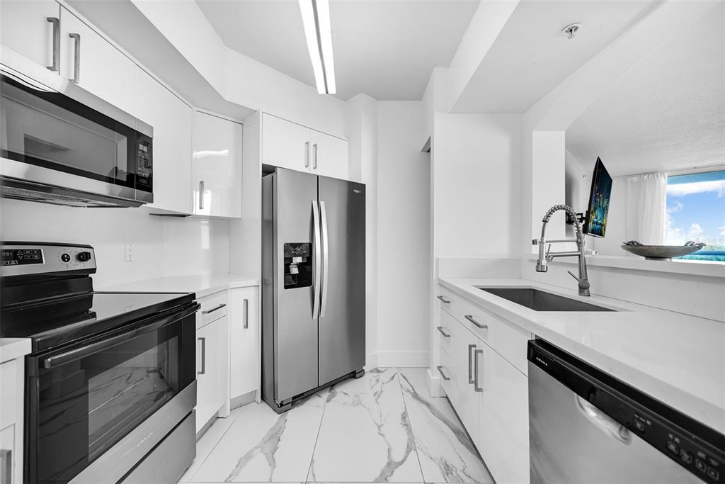 9201 Collins Avenue, Unit 821 Surfside, FL 33154 - Photo 47 of 60 a kitchen with stainless steel appliances granite countertop a stove a refrigerator and a sink