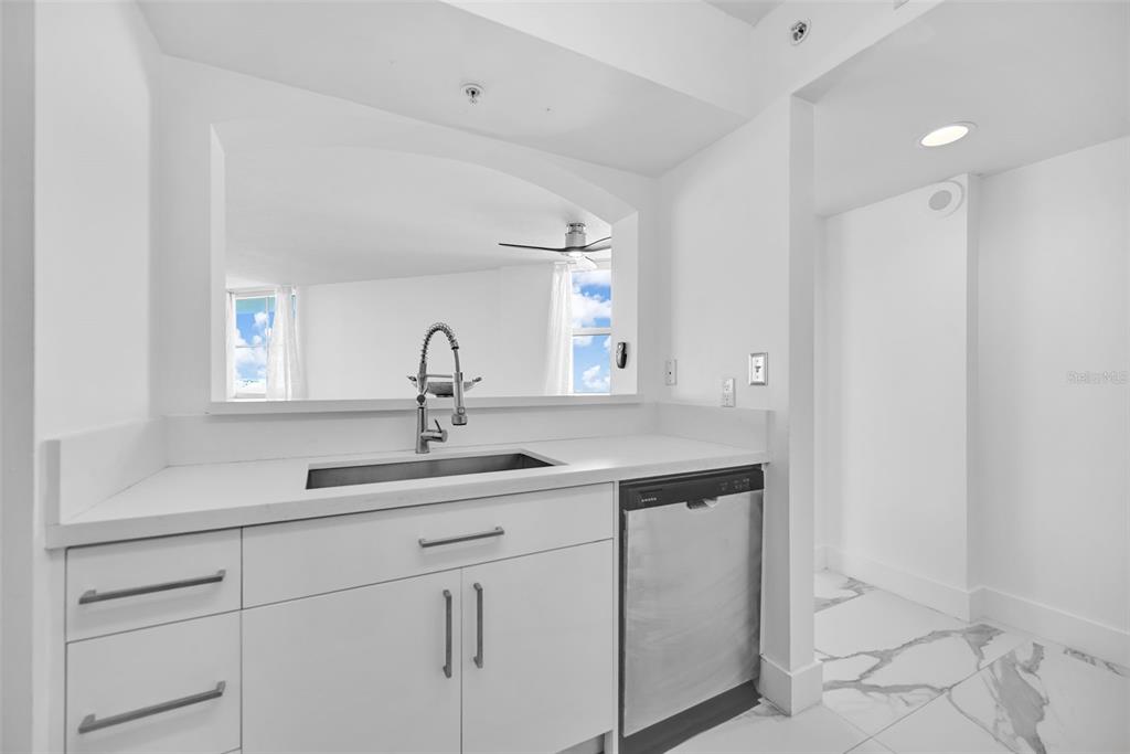 9201 Collins Avenue, Unit 821 Surfside, FL 33154 - Photo 49 of 60 a kitchen with a sink and a mirror