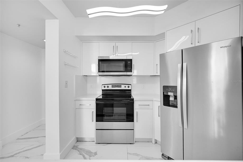 9201 Collins Avenue, Unit 821 Surfside, FL 33154 - Photo 50 of 60 a kitchen with stainless steel appliances and refrigerator