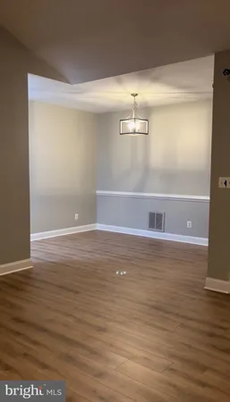 a view of water heater room with wooden floor