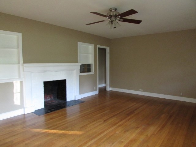 1730 Houston Lake Road Perry, GA 31069 - Photo 9 of 27 a view of empty room with wooden floor and fireplace