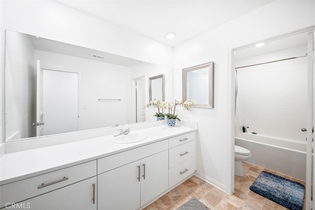5066 Banjo Way Hemet, CA 92545 - Photo 23 of 27 a bathroom with a double vanity sink a mirror and a bathtub