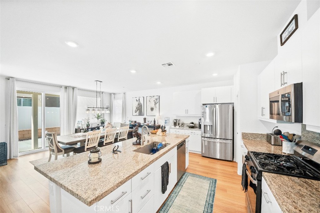 5066 Banjo Way Hemet, CA 92545 - Photo 7 of 27 a large kitchen with kitchen island granite countertop a large counter top appliances and cabinets
