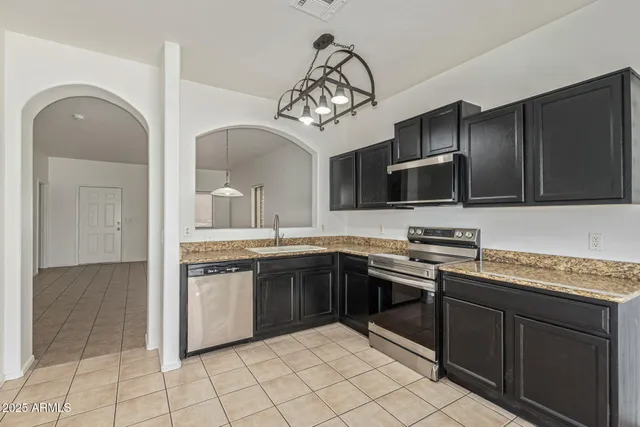a kitchen with stainless steel appliances granite countertop a sink and a stove