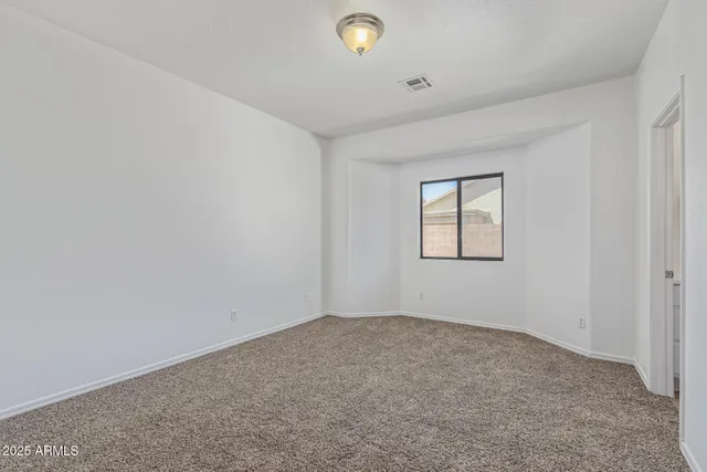 an empty room with windows and closet