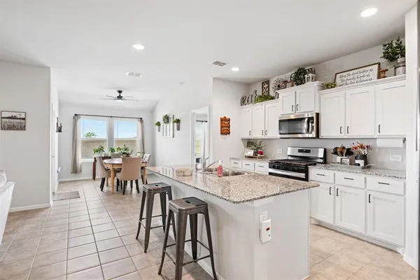 a kitchen with stainless steel appliances granite countertop a stove a microwave and cabinets