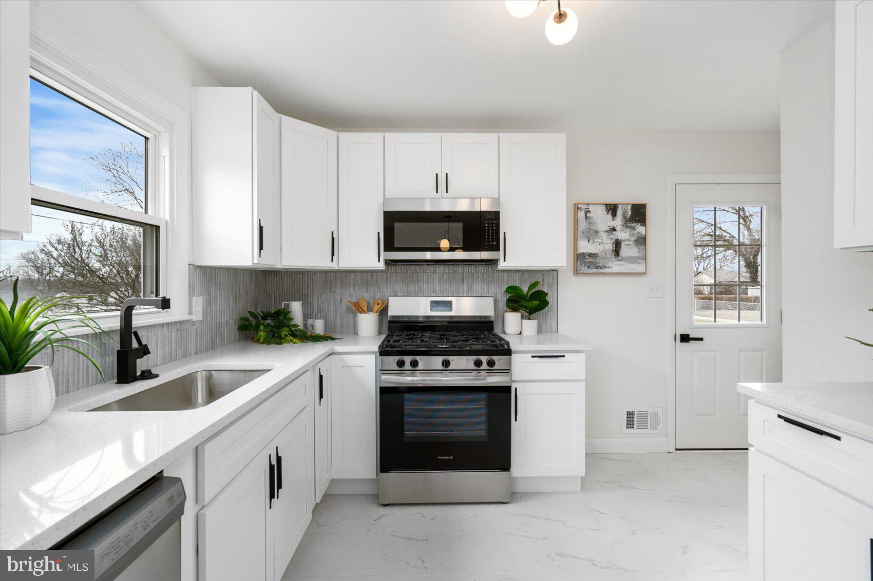 6809 Richardson Road Baltimore, MD 21207 - Photo 11 of 43 a kitchen with white cabinets and black appliances