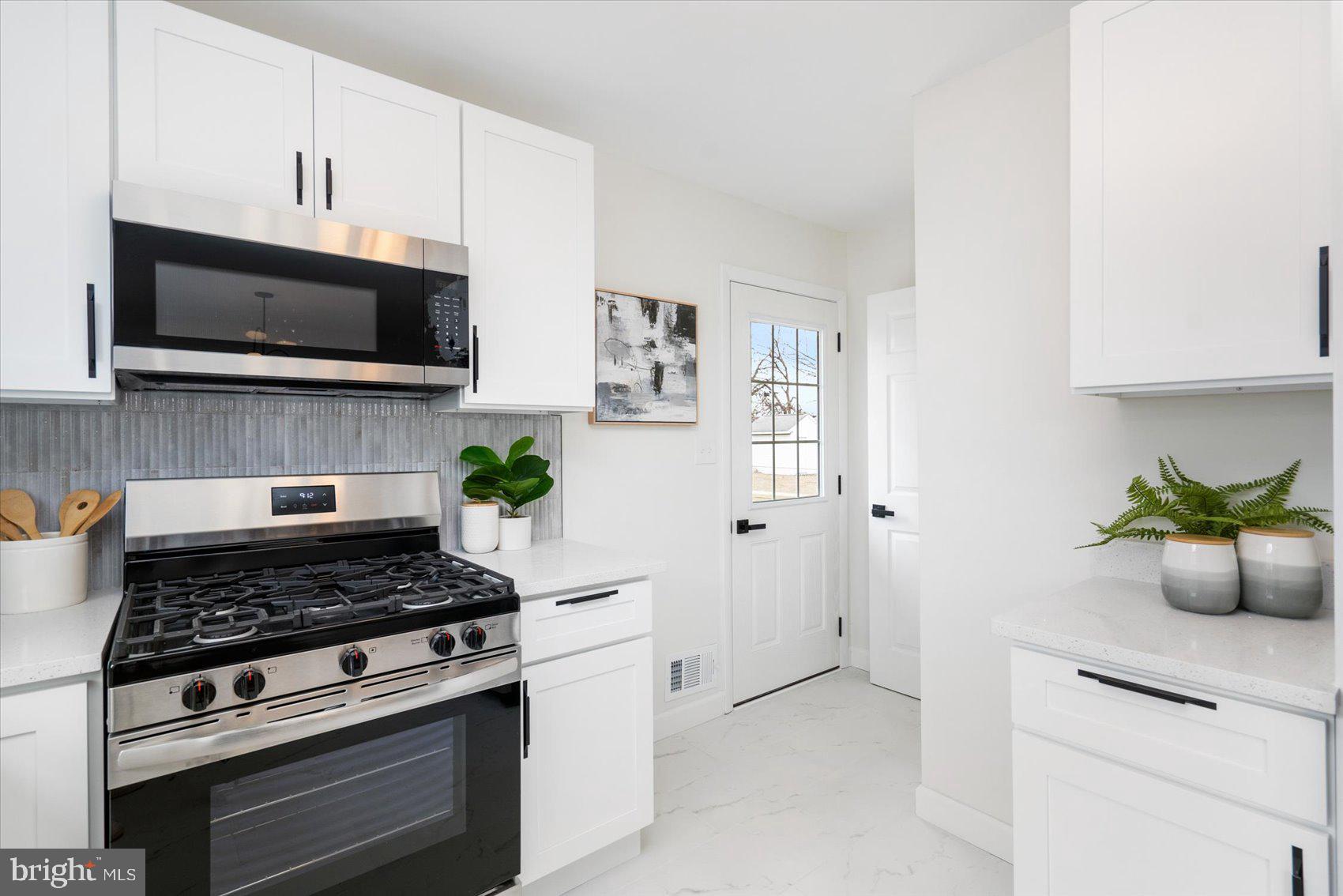 6809 Richardson Road Baltimore, MD 21207 - Photo 14 of 43 a kitchen with a stove and a white cabinets