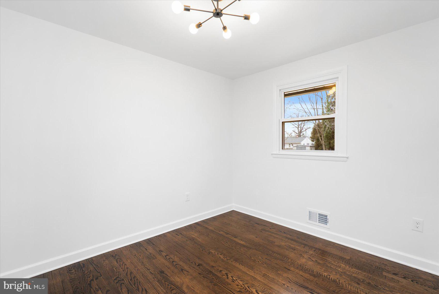 6809 Richardson Road Baltimore, MD 21207 - Photo 26 of 43 an empty room with wooden floor and windows