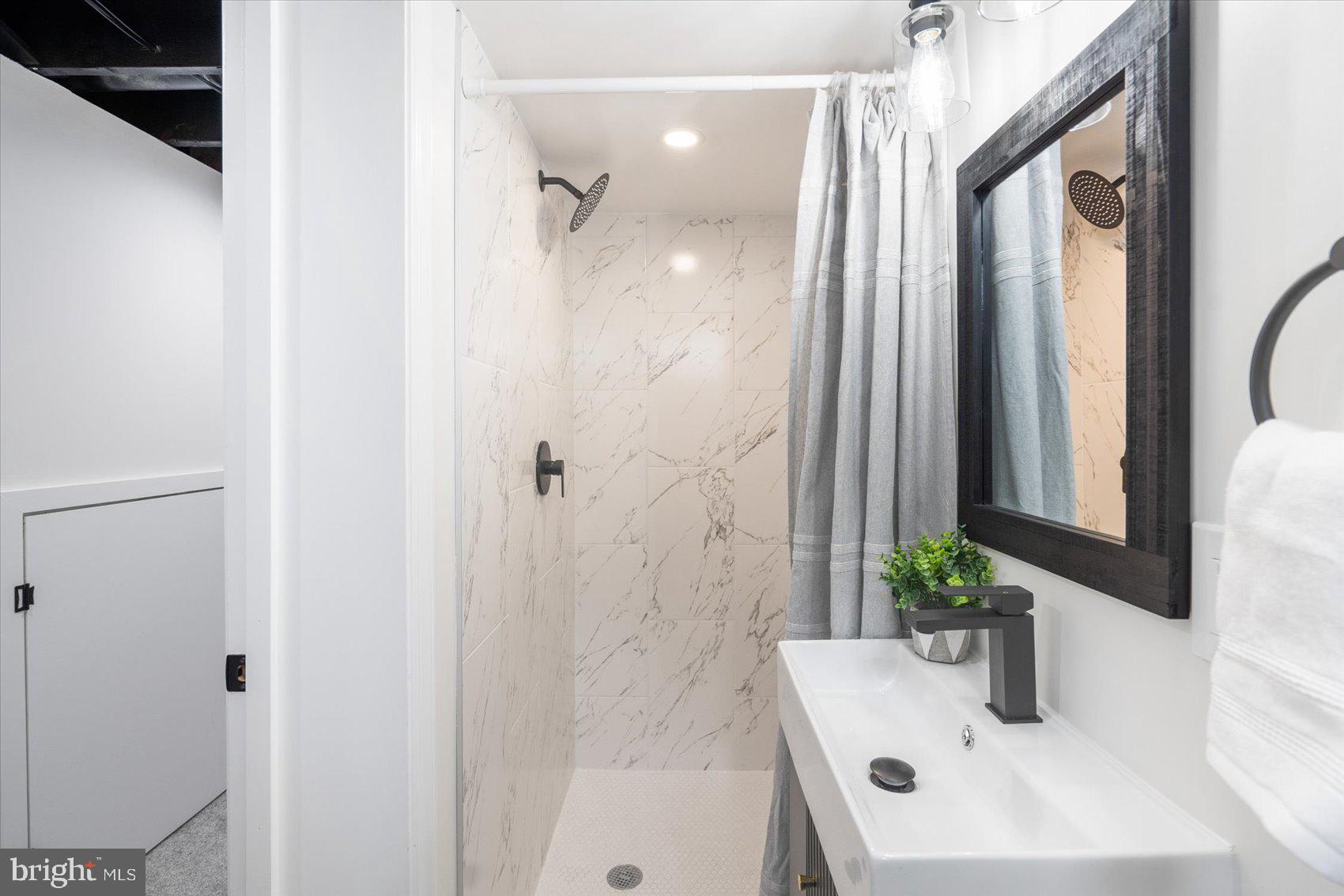 6809 Richardson Road Baltimore, MD 21207 - Photo 35 of 43 a bathroom with a sink a potted plant and a mirror