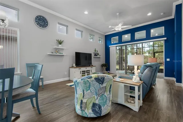 a living room with furniture kitchen view and a chandelier