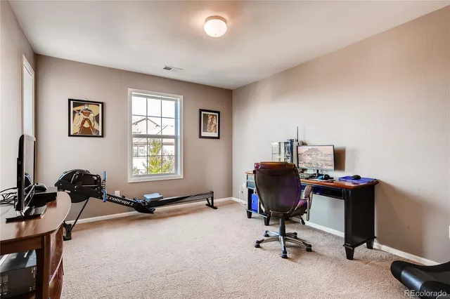 a view of a workspace with furniture and a window